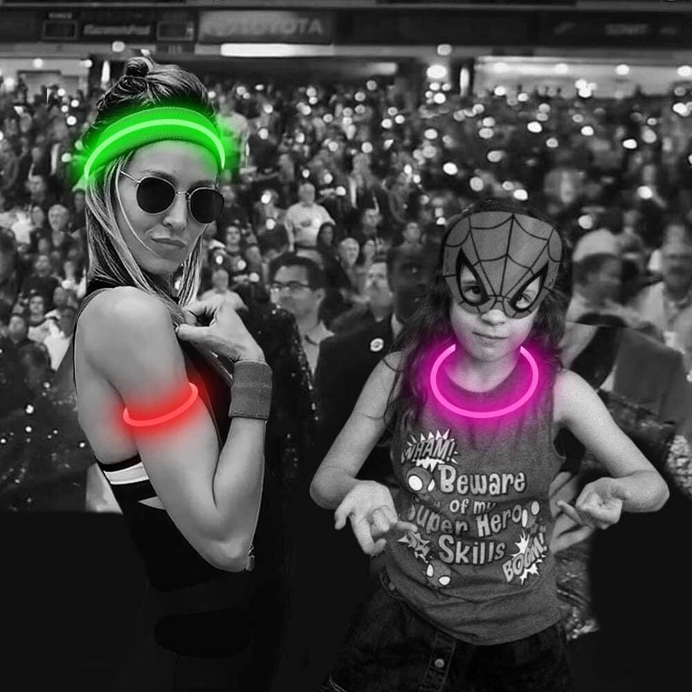 Two people wearing glow accessories, including headbands and bracelets, in a lively crowd setting with vibrant colors.
