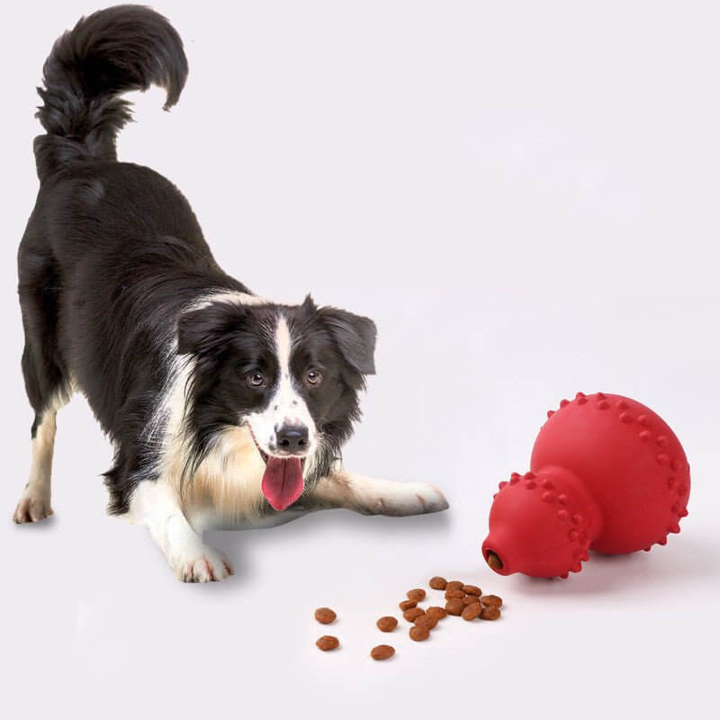 Dog playing with WuffWear Legebold - Snack & Bidestærk, a red durable toy filled with treats, perfect for stimulation and chewing.