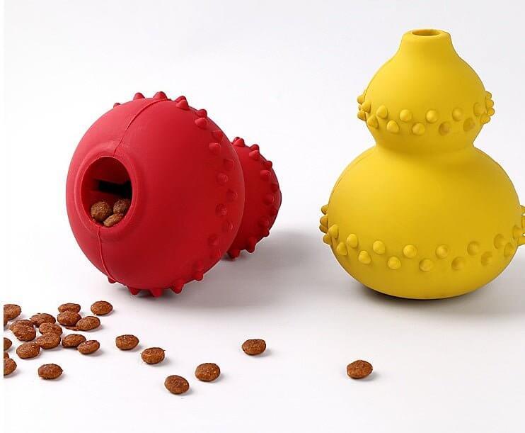 Red and yellow WuffWear Legebold - Snack & Bidestærk dog toys with treats, made of durable rubber for interactive play and learning.