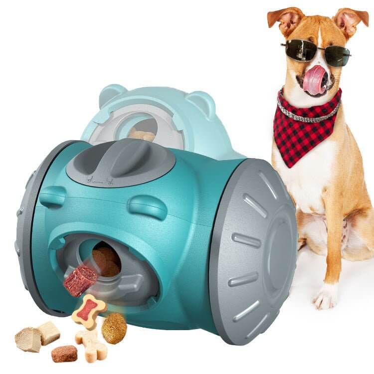 Interaktiv foder tumbler til hunde ved siden af en hund med solbriller og tørklæde, med forskellige godbidder foran.